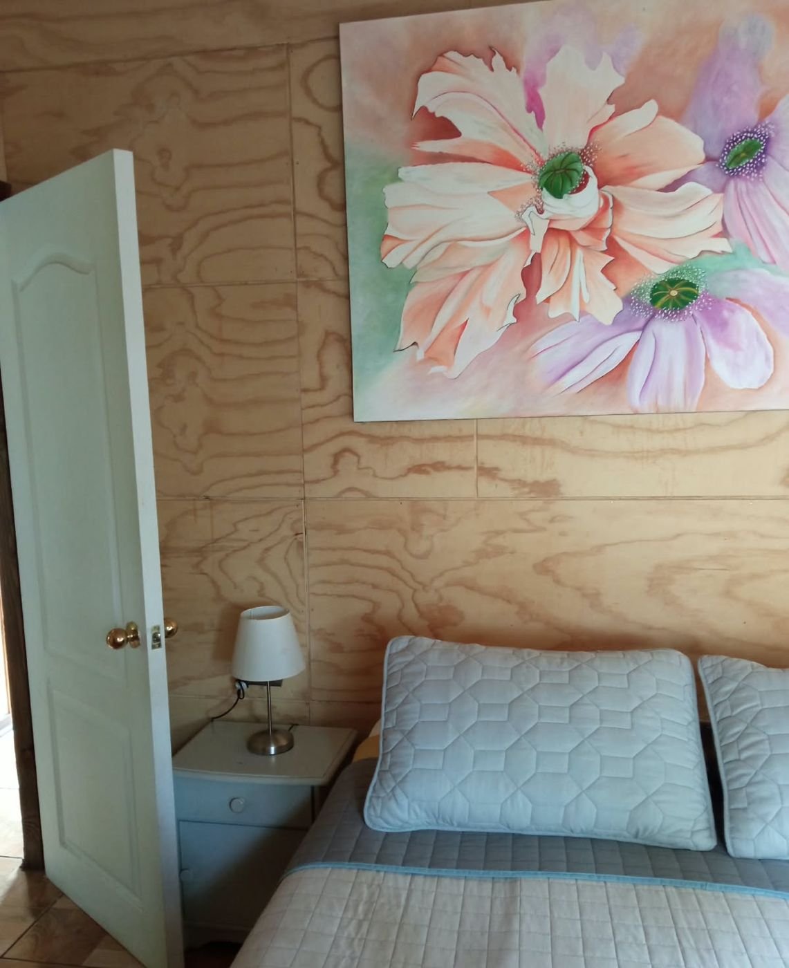 Cama con velador junto a la puerta