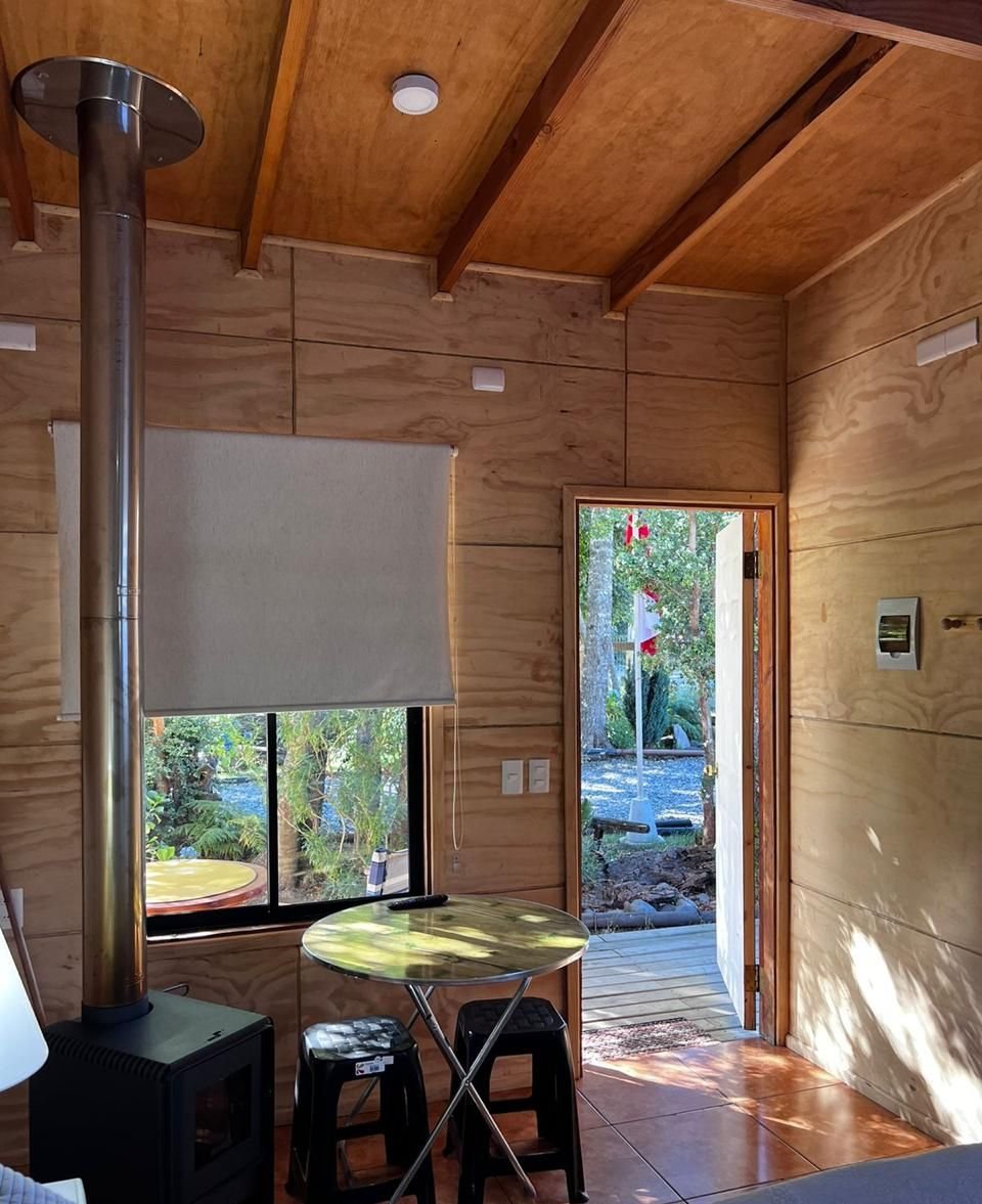 Estufa a leña junto a mesa pequeña y ventana