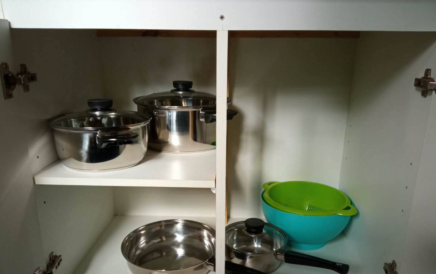 Ollas y utensilios en el mueble de cocina